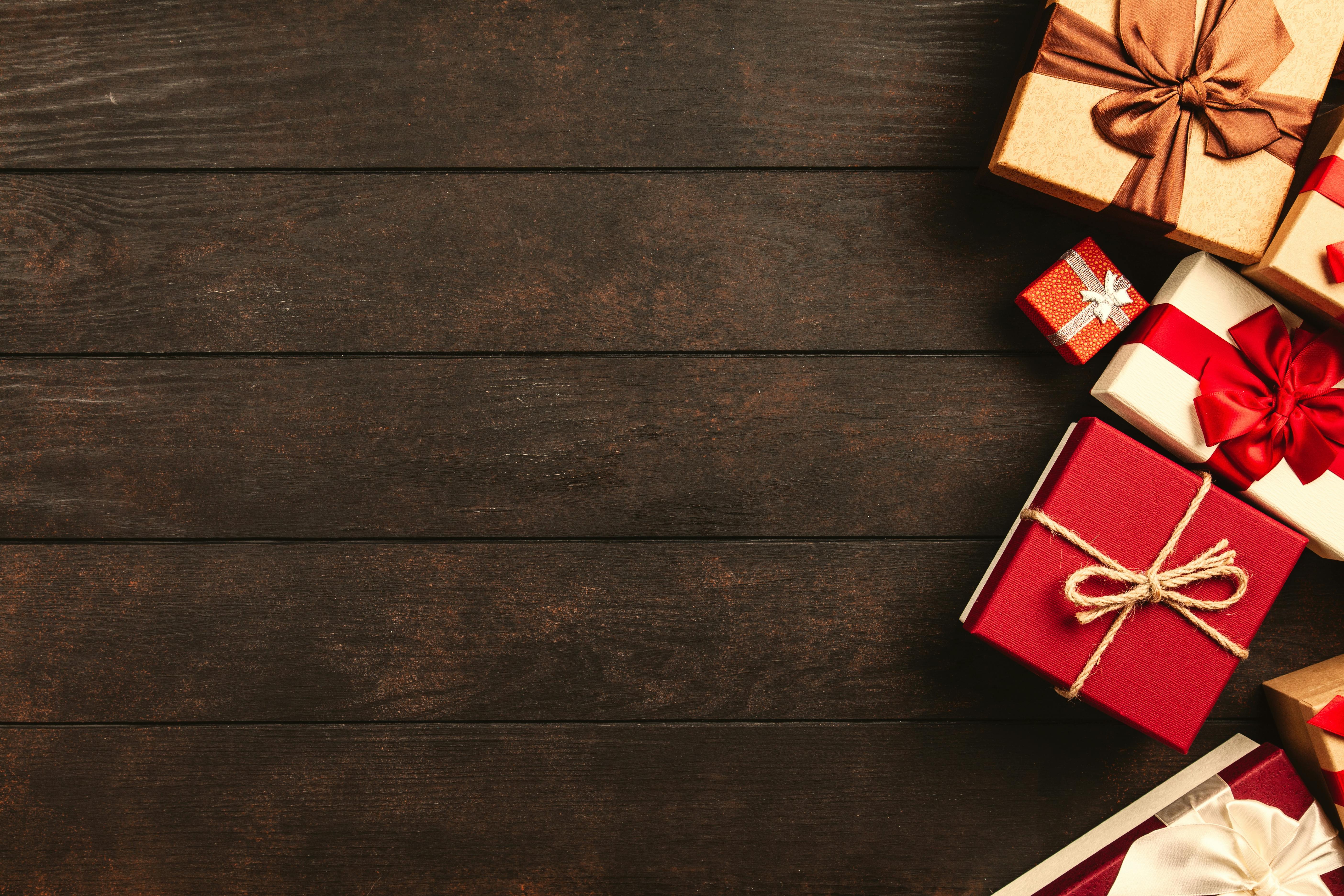 Rot und golden verpackte Geschenke auf einem Braunen Hintergrund.